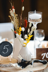 Elegante Hochzeitstafel mit stilvoller Tischdekoration und nummerierten Plätzen

