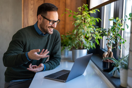 Successful happy professional business man working on her laptop in a bright home office