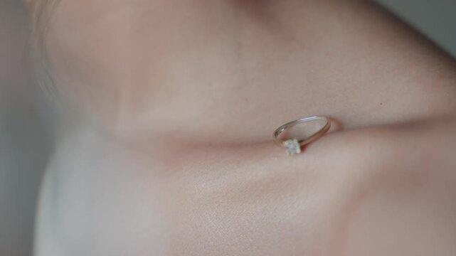 Soft close up of engagement ring on a woman&rsquo;s collarbone