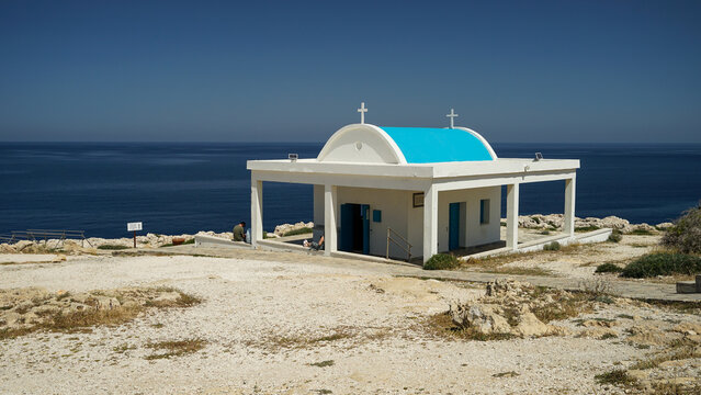 Greek Orthodox Church with blue roof sitting on cliff above sea, Ayioi Anargiroi Church, Cyprus