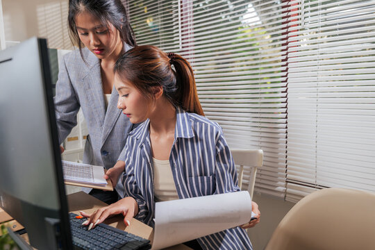 Two young women work home office business team, collaborating on computer, learning from online tasks, reviewing important documents, discussing project strategy, engaged with shared goals - Powered by Adobe