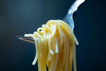 Close up of a fork twirling spaghetti, with the strands hanging down enticingly