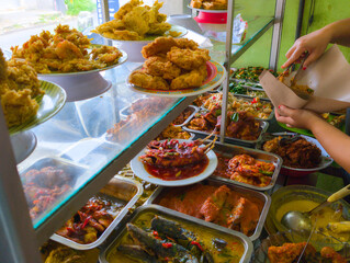 Waiter serving side dishes at an Indonesian food buffet stall