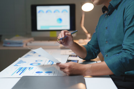 Business person analyzing financial data charts document - Powered by Adobe