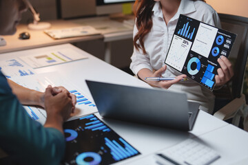 Business professionals discussing financial data charts in office
