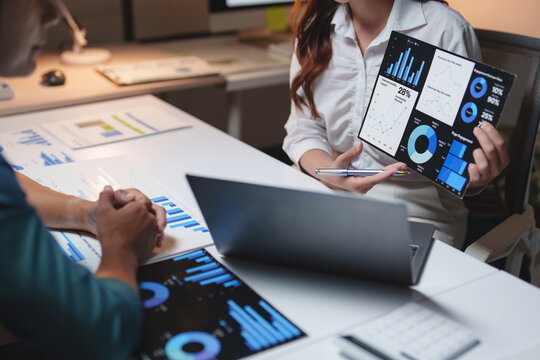 Business professionals discussing financial data charts in office