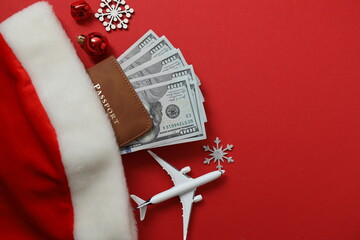 Christmas travel. Top view of passport, money, gift image on red background with space for design.
