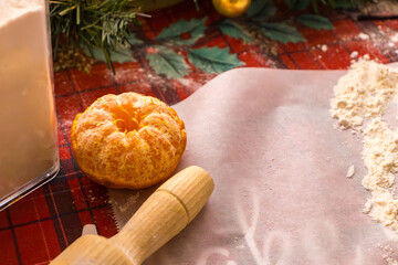 Homemade Christmas cookie preparation with dough, flour, cookie cutters and festive decorations on a kitchen table. Holiday baking process with ingredients and gingerbread shapes.