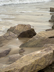Rocky shoreline with waves at Tharangambadi beach in Tamil Nadu, showing weathered coastal rocks...