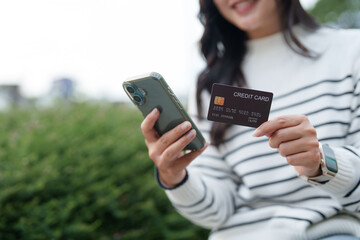 Woman holding smartphone and credit card for online payment