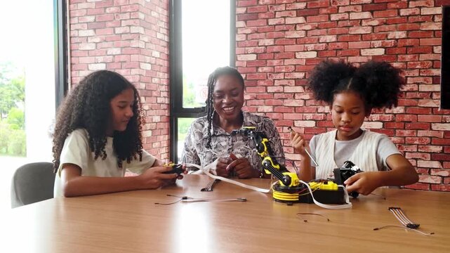 Happy kids celebrate success in a robotics classroom, high-fiving their teacher after completing a STEM coding project. Diverse group with teamwork and innovation spirit in educational tech learning.