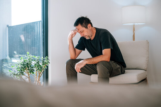 Mature adult caucasian man, looking worried and deep in thought. Mental health, stress, crisis, and midlife themes.