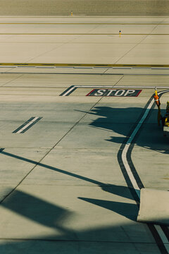 Directional markings and long shadows stretch across the airport.