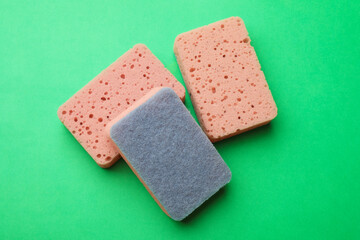 Kitchen sponges on green background, flat lay