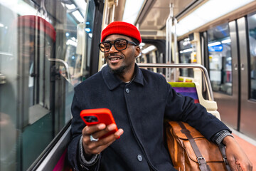 Young black man commuting on public transport checking phone