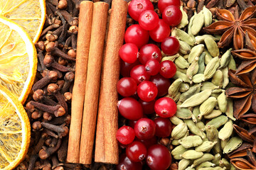 Different spices, dry orange slices and cranberries for mulled wine as background, top view