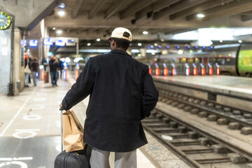 Man waiting on train station platform for travel