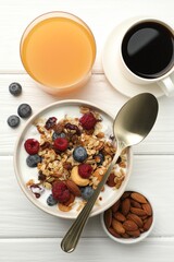 Healthy breakfast. Oatmeal with nuts, berries and milk served on white wooden table, flat lay