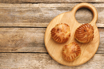 Tasty profiteroles on wooden table, top view. Space for text