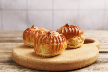 Tasty profiteroles on wooden table, closeup. Space for text