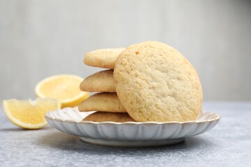 Tasty lemon cookies and fruit slices on grey table, closeup