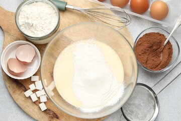 Different ingredients for dough and whisk on grey table, flat lay