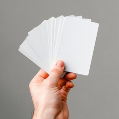 A hand holding a deck of white playing cards