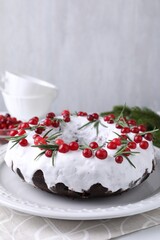 Tasty Christmas cake with cranberries and rosemary on table against light background, closeup. Space for text