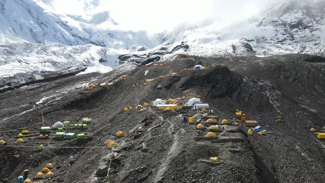 Drone footage showcases Manaslu Base Camp below the 8,163m Himalayan peak. The scene reveals snowy ridges, rugged terrain, and the dramatic high-altitude environment of this remote mountain region.