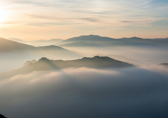 Fototapeta premium Paysage de montagne minimaliste dans la brume au lever du soleil