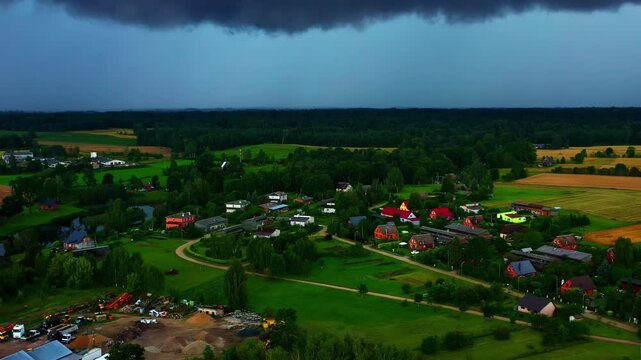 Small rural village under ominous pre-storm sky in late summer aerial view