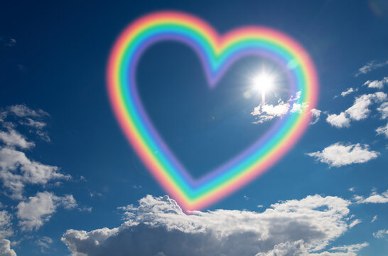 Symbolic colorful heart shaped rainbow frame in blue sky with sun and white clouds. - Powered by Adobe