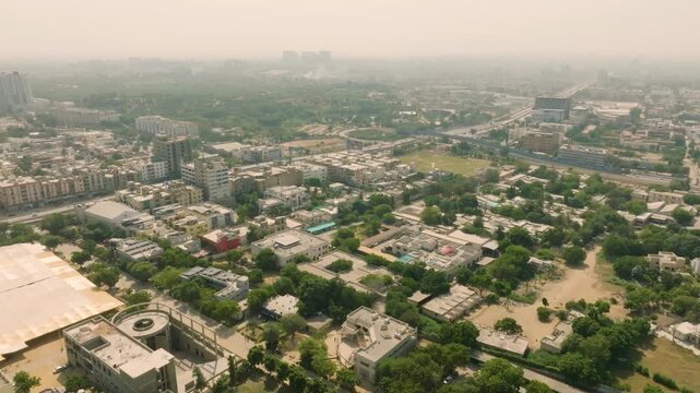 High altitude wide-angle drone footage over NED University in Karachi, capturing the campus architecture against a backdrop of the city skyline fading into atmospheric haze.