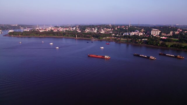 panaji city with mandovi river, cargo ships and greenery at goa. day time, push back shot, drone shot, 4k.