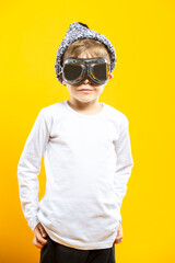 Youth Lifestyle Concept. Positive Caucasian Boy Wearing Aviation Protective  Goggles and White Shirt isolated Over Yellow Background as Image To Portray Intelligence, Childhood Ideas
