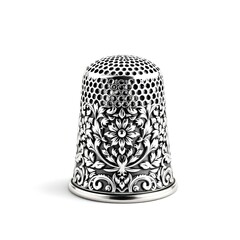 Ornate sterling silver antique sewing thimble featuring detailed floral engraving isolated on white background