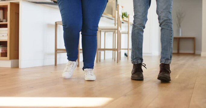 Diverse friends starting dance footwork with synced taps on floor in kitchen practicing routine