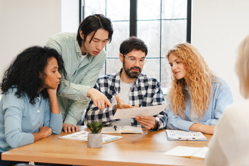 Diverse business team collaborating during a meeting, discussing documents and ideas