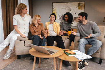 Diverse team collaborating during informal meeting in comfortable office space