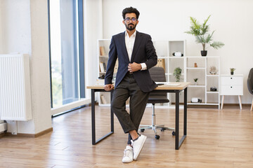 A well-dressed businessman poses confidently in a contemporary office setting, exuding professionalism and success