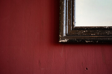赤い壁に飾られた古い額縁
