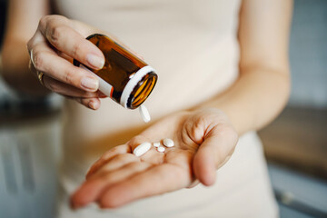 Woman pouring pills from bottle into her hand