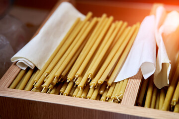 a stack of new wax candles in the church
