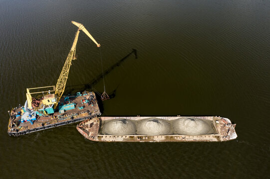 Cleaning the river bottom with a crane and a barge top view