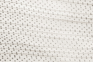 Cloud Dancer fabric with polka dots in a repeating pattern, a soft texture