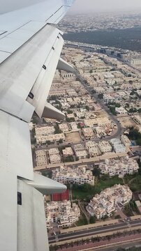 Airplane flying above Dubai in UAE, side window view