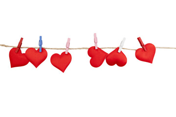 Red fabric hearts hang on a line with clips. This setup is perfect for creating a decoration for Valentine's Day celebrations at home or in a classroom.