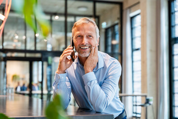 Smiling professional on mobile phone in modern office environment