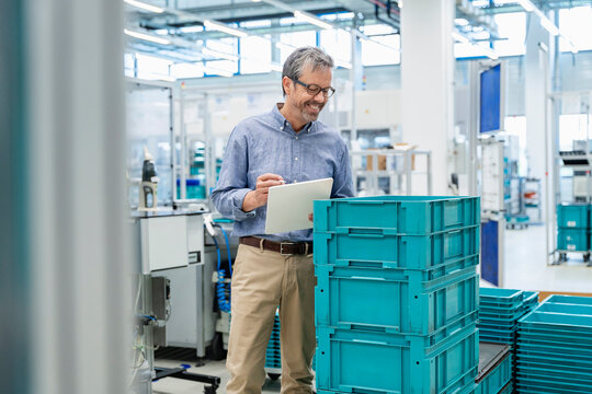Engineer checking products with clipboard in modern industrial workplace