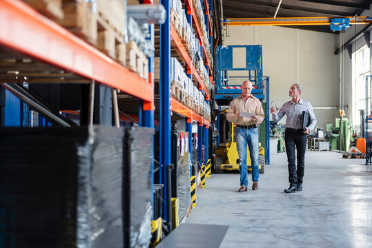 Employees discussing in a production hall at a warehouse facility